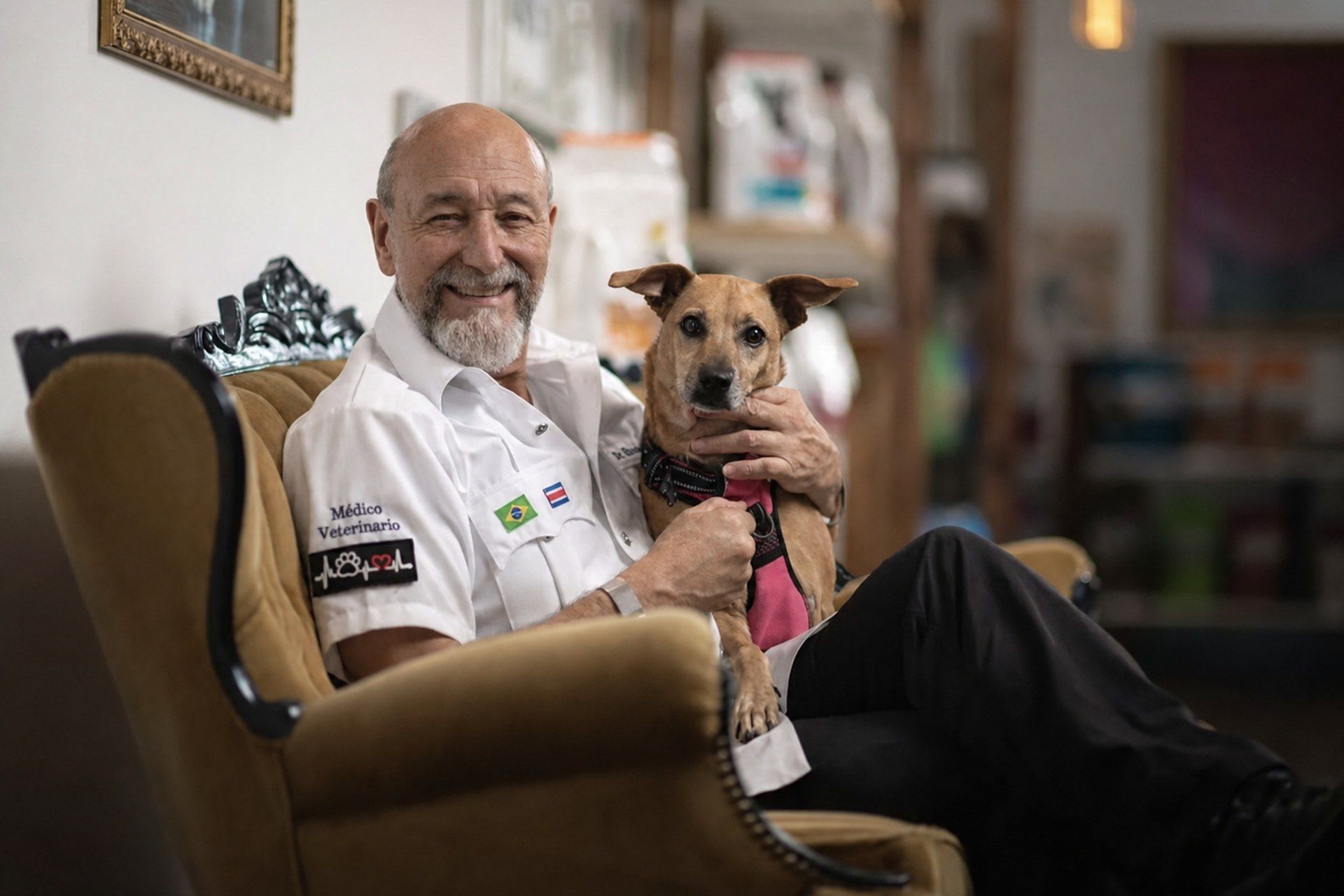 El Dr. Bitter sosteniendo en brazos a un perro paciente de la clínica